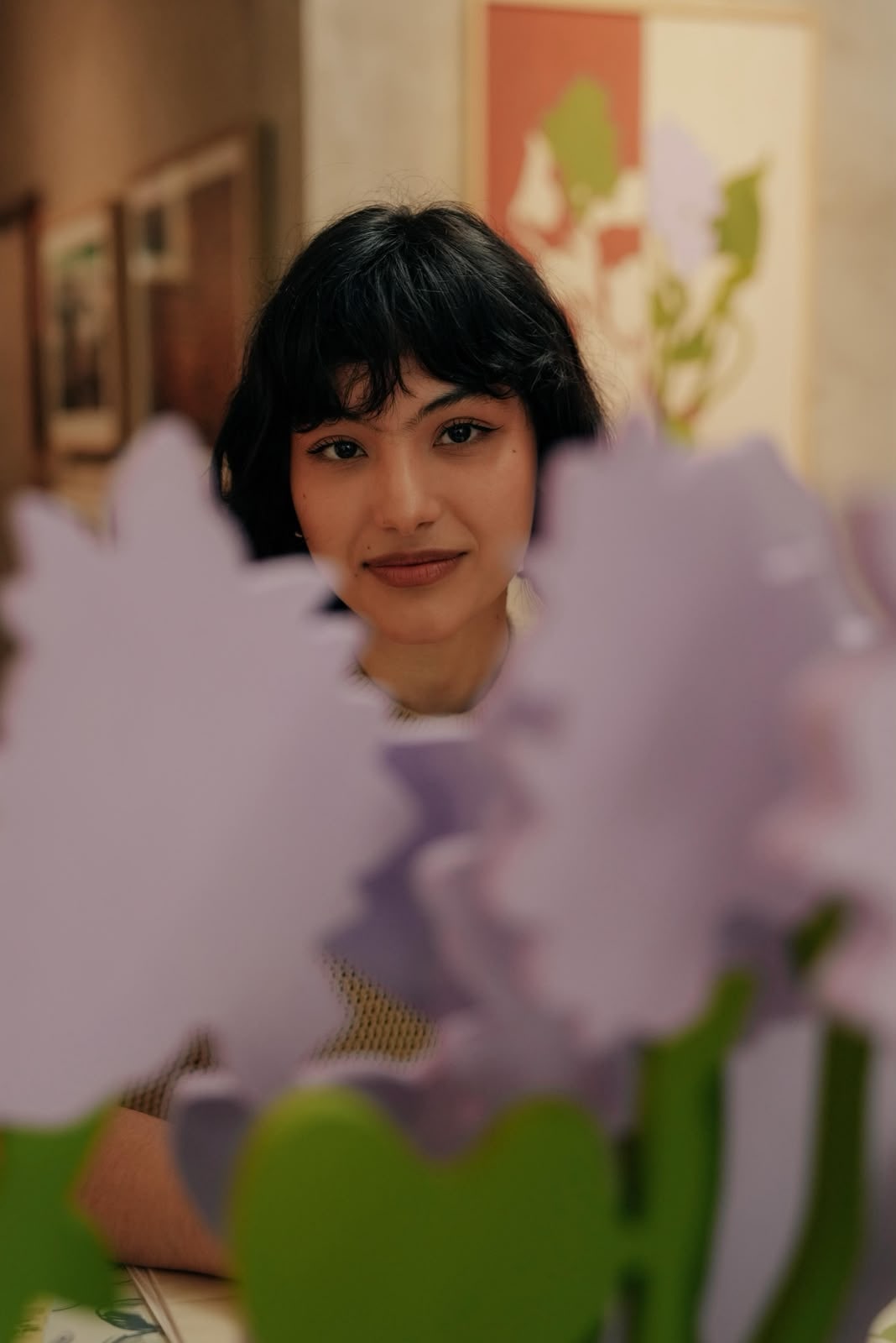 Bianca Fernández vista entre flores de la exposición PerfLue: Espejo de Agua