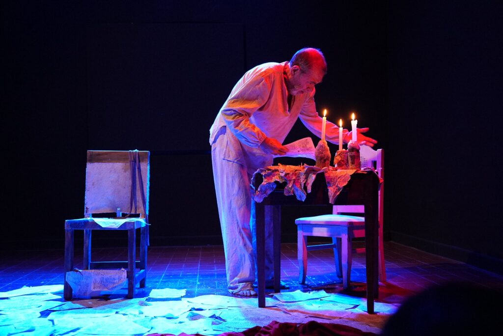 Héctor Silva junto a una mesa y velas durante una función de El Loco de Cervantes