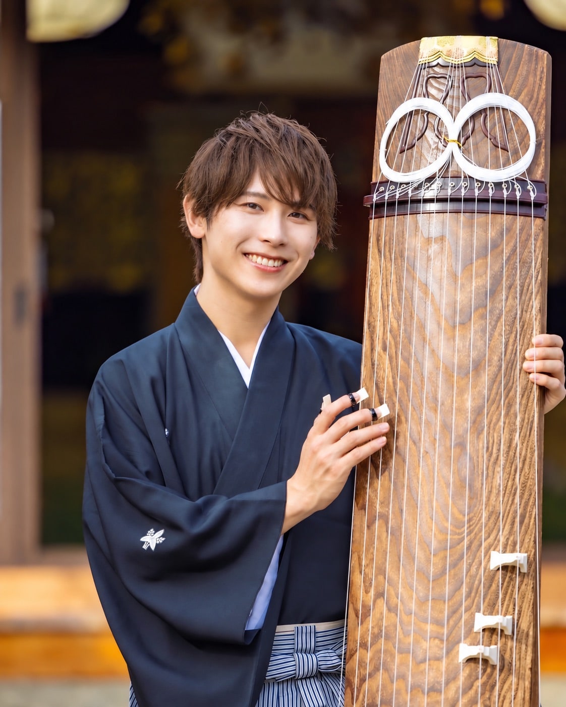 El músico japonés Yoshiaki Okawa posa junto a un koto
