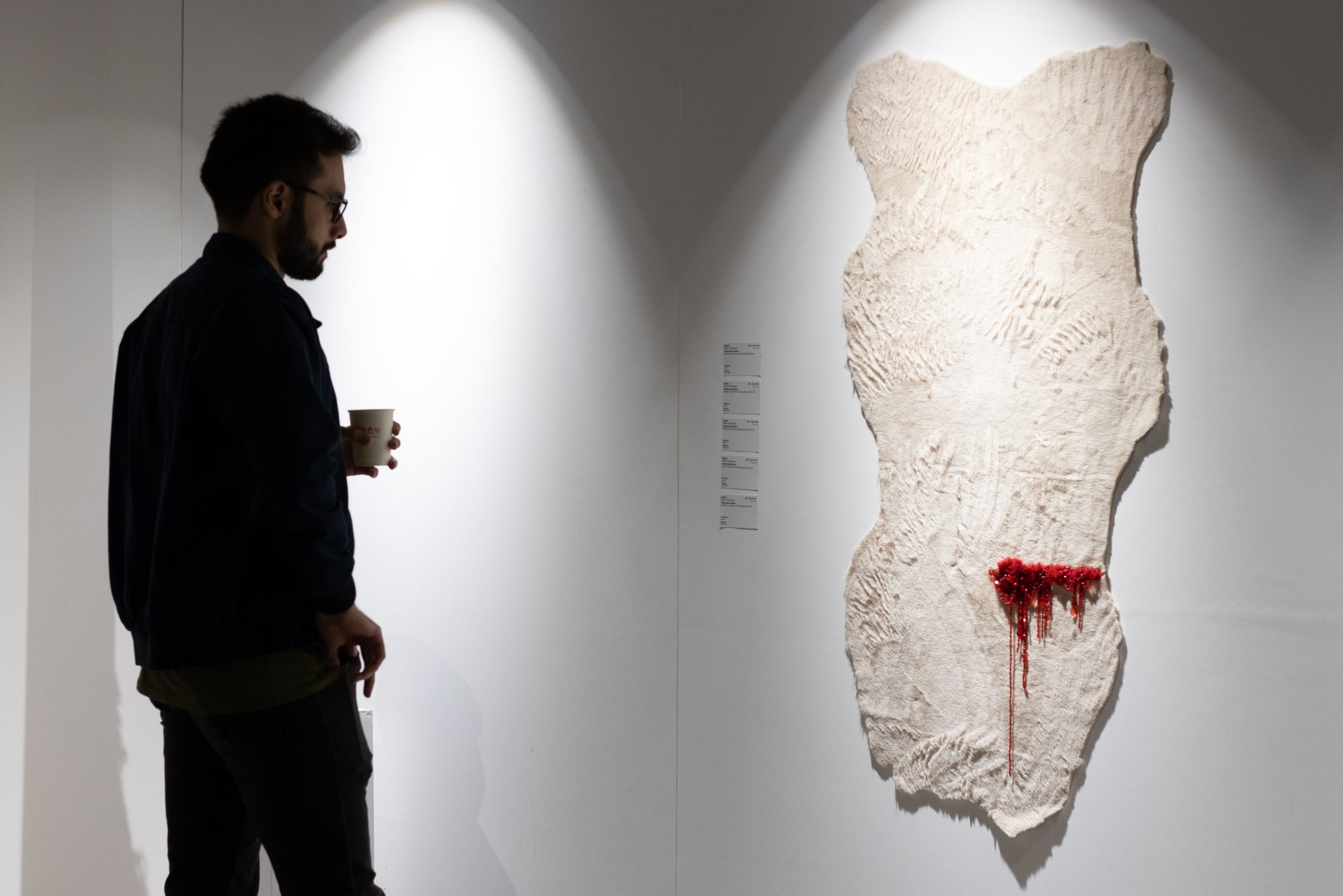 Un visitante observa una obra textil en Oxígeno Feria de Arte
